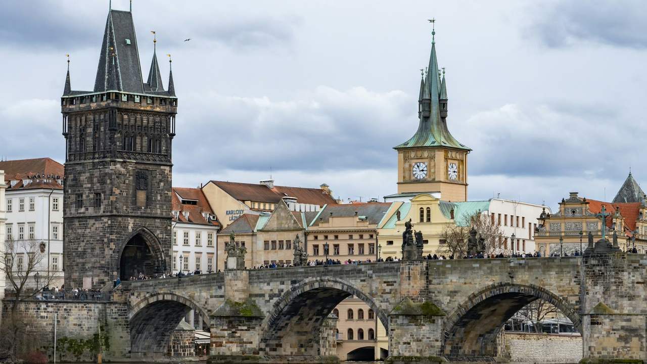 Podul Carol din Praga, cu turnul vechi și statuile, deasupra râului