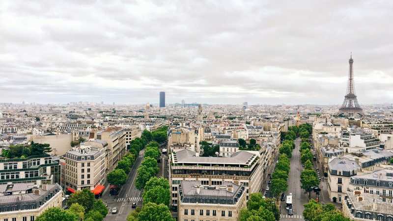 Paris văzut de la Arcul de Triumf, cu Turnul Eiffel în dreapta și acoperișurile orașului