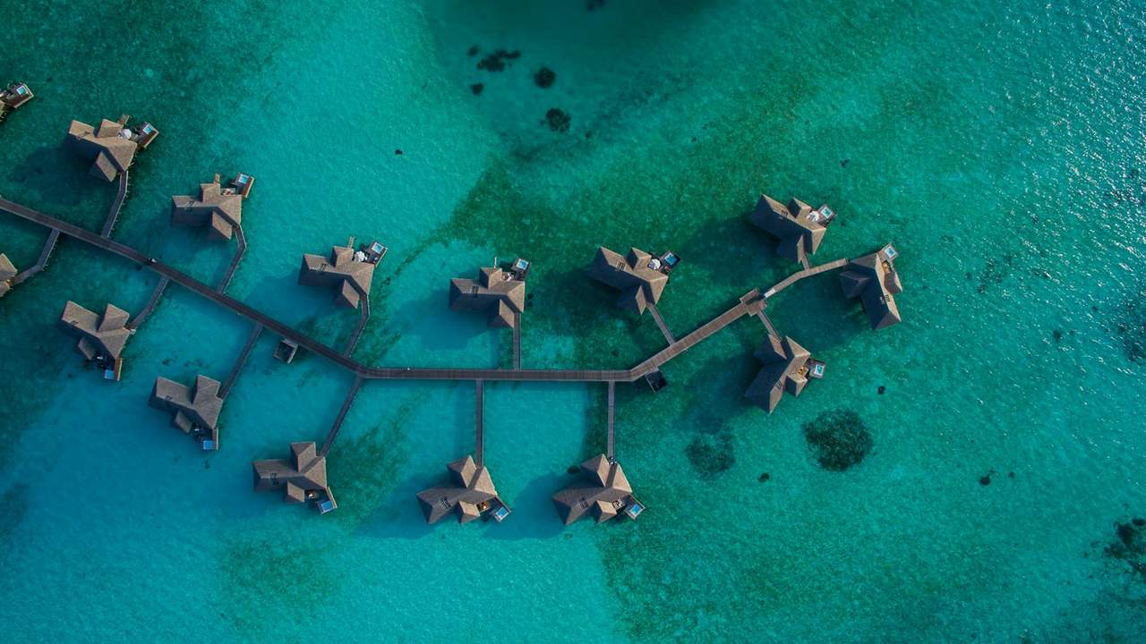 Vile pe piloni deasupra apei turcoaz, în Maldive, văzute de sus