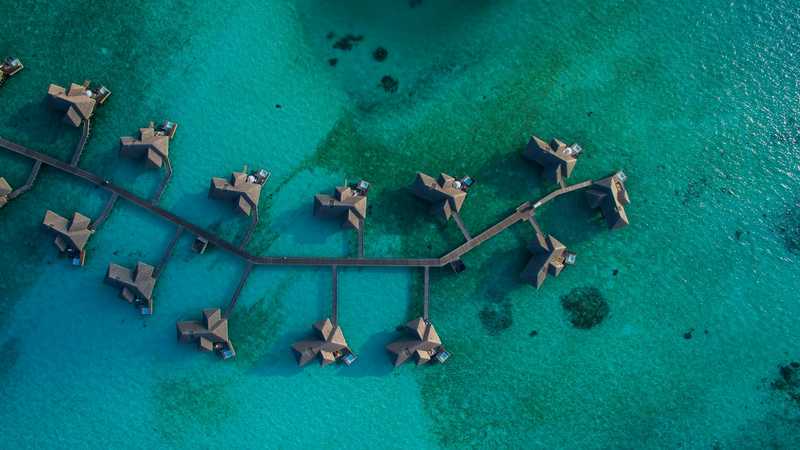 Vile pe piloni deasupra apei turcoaz, în Maldive, văzute de sus