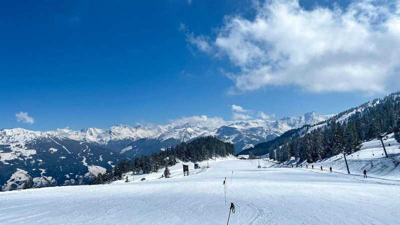 Pârtie de schi înzăpezită în Zillertal, Austria, cu schiori și munți