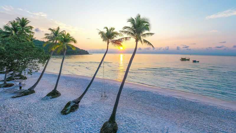Plaja Sao din Phu Quoc, cu palmieri pe nisip și o barcă pe apă