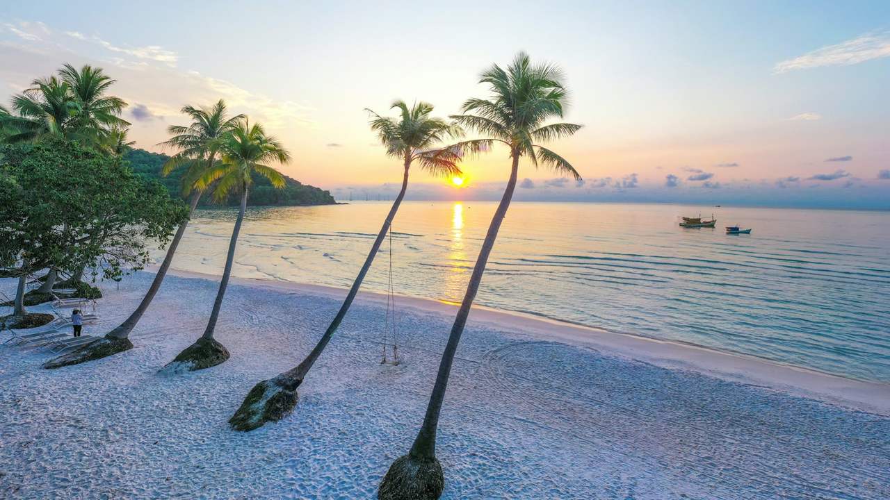 Plaja Sao din Phu Quoc, cu palmieri pe nisip și o barcă pe apă