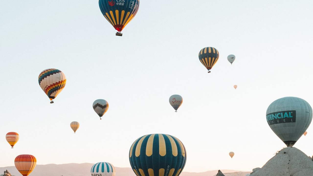 Baloane cu aer cald deasupra văii stâncoase din Cappadocia, Turcia, la răsărit